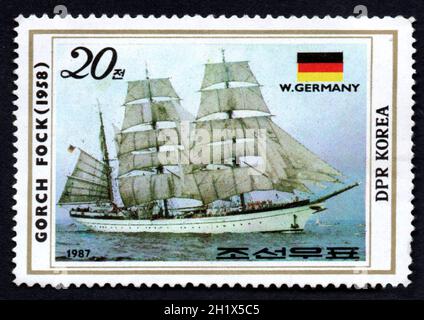 DPR Korea - UM 1987: Koreanische Briefmarke, die dem alten Segelschiff gewidmet ist. Das deutsche Segelschiff Gorch Fock auf See. Segelboot auf einem poststam abgebildet Stockfoto