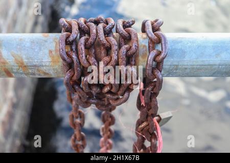 Rostige Kette um Metallstangen im Hafen von Kiel Stockfoto