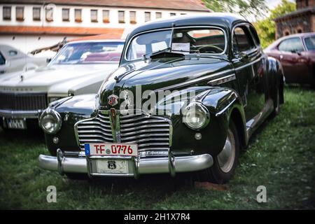 DIEDERSDORF, DEUTSCHLAND - 21. AUGUST 2021: Das Kleinwagen Buick Special Sedanette, 1941. Fokus auf Zentrum. Wirbeliges Bokeh. Die Ausstellung von 'US Car Clas Stockfoto