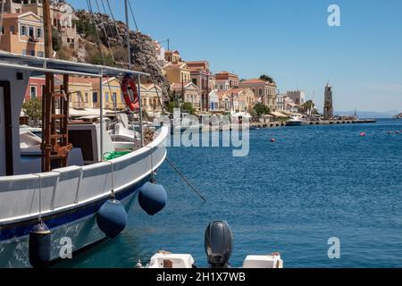 SYMI, Griechenland - 03. JUNI 2021. Der Hafen von Symi Stadt mit den Bezirken Chorio und Gialos ist einer der schönsten und romantischsten in der ganzen A Stockfoto