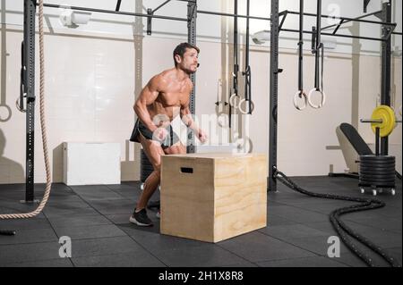 Vollaufnahme eines jungen kaukasischen Sportlers, der allein beim Boxspring-Training im Fitnessstudio trainiert. Hochwertige Fotos. Stockfoto