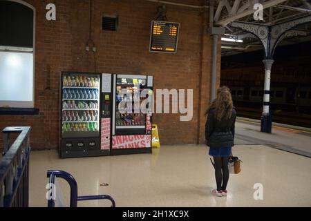 Doncaster, Vereinigtes Königreich, 22. Mai 2021: Eine junge Frau studiert nachts nach einer Stornierung an der Abfahrtstafel des Bahnhofs doncaster Stockfoto