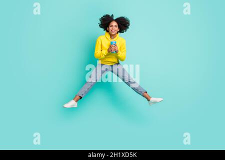 In voller Länge Körpergröße Foto Frau springen trinken Cola isoliert hell blaugrün Hintergrund Stockfoto
