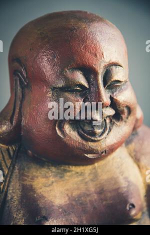 Traditionelle Holzstatue des chinesischen Buddha isoliert auf dunklem Hintergrund Stockfoto