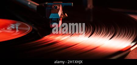 Nadeldetails auf Vinyl-Schallplatte auf Plattenspieler, Bild bei schwachem Licht mit Reflexion Stockfoto