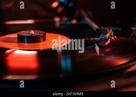 Nadeldetails auf Vinyl-Schallplatte auf Plattenspieler, Bild bei schwachem Licht mit Reflexion Stockfoto