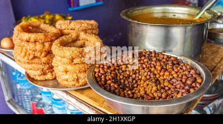 Nepalesisches Essen Frühstück mit Sel Roti und Kichererbsen. Ring Road in Kathmandu, Nepal. Stockfoto