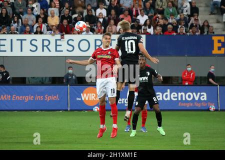 Augen zu und durch beim Kopfballduell gegen Nils Petersen (Freiburg) und Arne Maier (FC Augsburg), 1. FBL: 21-22: 6. Spt. SC Freiburg gegen FC Augsburg Stockfoto