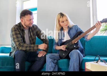 Vater lehrt Teenager-Tochter, die E-Gitarre zu spielen. Stockfoto