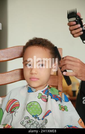 salvador, bahia, brasilien - 18. oktober 2021: Kind schneidet Haare in einem Wohnsitz in der Stadt Salvador. Stockfoto
