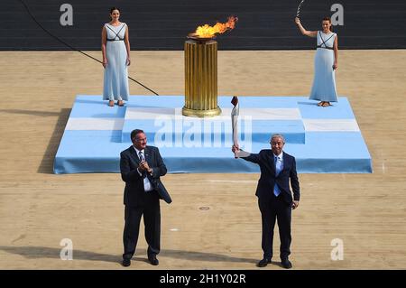 Athen, Griechenland. Oktober 2021. Yu Zaiqing (R), Vizepräsident des chinesischen Olympischen Komitees, hält die Fackel während der Zeremonie, um die Flamme für die Olympischen Winterspiele 2022 in Athen im Panathenaic-Stadion zu übergeben. Die Olympischen Winterspiele werden vom 4. Bis 20. Februar 2022 in Peking stattfinden. Quelle: Angelos Tzortzinis/dpa/Alamy Live News Stockfoto