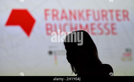 19. Oktober 2021, Hessen, Frankfurt/Main: Eine Frau steht vor einer Projektion am Rande der Eröffnungspressekonferenz der Frankfurter Buchmesse. Das diesjährige Gastland ist Kanada. Foto: Arne Dedert/dpa Stockfoto