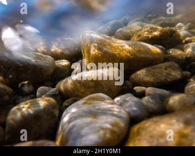 Kieselsteine steinigen unter der Wasseroberfläche in der Nähe des Seeufers, natürliche Szene, Nahaufnahme Stockfoto