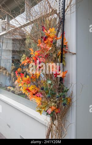 Herbstblumen und Blätter sind vor dem Winchcombe Flower Shop in der Winchcombe High Street in den Cotswolds, Gloucestershire, zu sehen Stockfoto