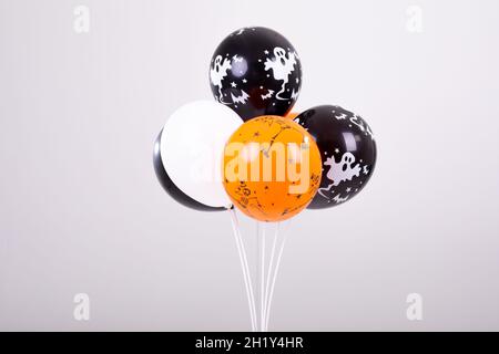 Orangefarbene, schwarz-weiße halloween-Ballons auf weißem Hintergrund Stockfoto