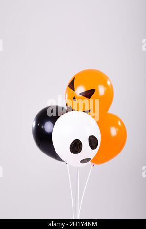 Orangefarbene, schwarz-weiße halloween-Ballons auf weißem Hintergrund Stockfoto