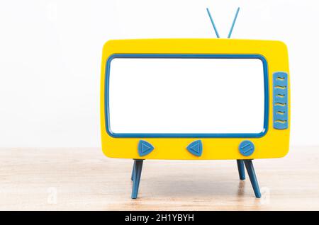 Vintage Miniatur-Spielzeug-Fernseher auf Holztisch. Stockfoto