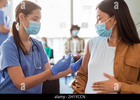 Schwanger Asiatische Dame Erhalten Impfstoff Jab In Arm Stockfoto