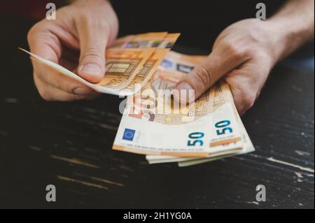 Geschäftsleute zählen Geld. Reiche männliche Hände hält und zählen Geldscheine von 50 Euro Scheine oder Banknoten Währung Stockfoto