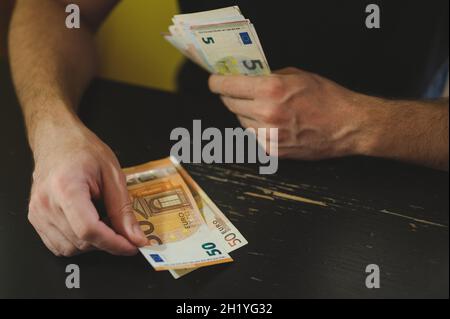 Geschäftsleute zählen Geld. Reiche männliche Hände hält und zählen Geldscheine von 50 Euro Scheine oder Banknoten Währung Stockfoto