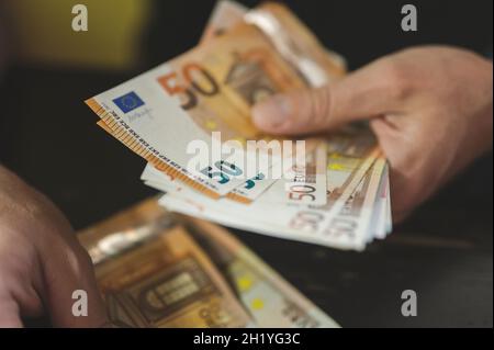 Geschäftsleute zählen Geld. Reiche männliche Hände hält und zählen Geldscheine von 50 Euro Scheine oder Banknoten Währung Stockfoto