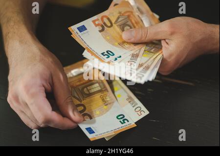 Geschäftsleute zählen Geld. Reiche männliche Hände hält und zählen Geldscheine von 50 Euro Scheine oder Banknoten Währung Stockfoto