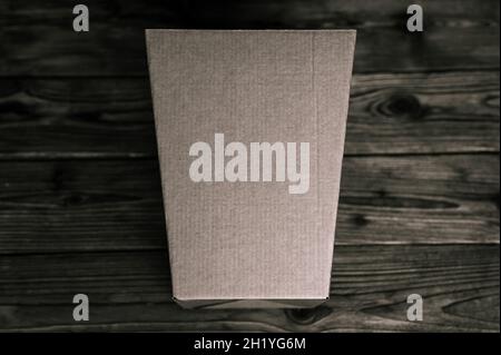 Mockup leere Handwerk trapezförmigen Karton auf einem alten Holztisch Nahaufnahme. In schwarzer Farbe getönt. Draufsicht, flache Lage und Platz für Text Stockfoto
