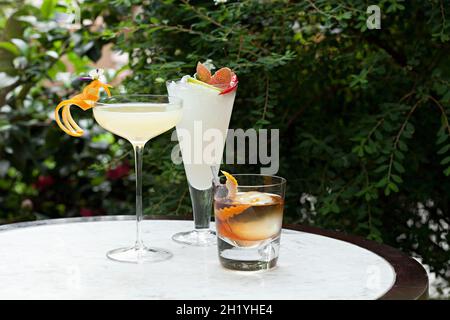 Set mit drei Cocktails auf einem Tisch im Garten Stockfoto