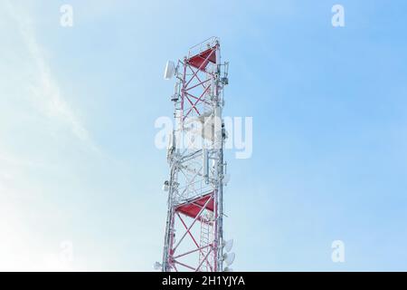 Frozen Cellular Tower in den Bergen. Telekommunikationsturm mit vielen verschiedenen Antennen für die Signalübertragung. Sonniger Wintertag. Wintereinbruch Stockfoto