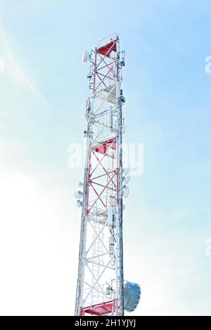 Telekommunikationsturm mit vielen verschiedenen Antennen zur Übertragung von Fernseh- und Funksignalen. Frozen Cellular Tower in den Bergen. Winterindustrie Stockfoto