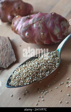 Eine Anordnung von Quinoa-Samen auf einem Silberlöffel mit Jerusalemer Artischocken Stockfoto