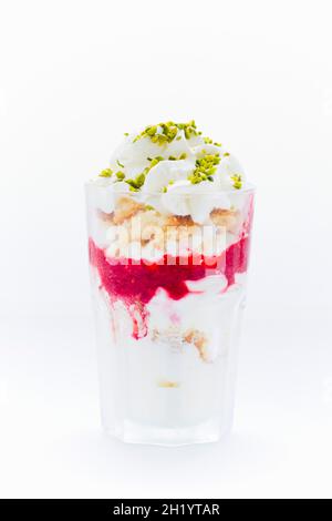 Gefrorener Joghurt mit Vanillekuchen, Meringue, Himbeerpüree, Pistazien und Rahm Stockfoto