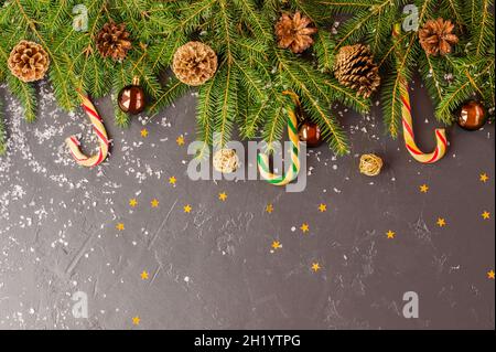 Weihnachtshintergrund mit Platz für Ihren Text. Grüne Äste Fichte mit goldenen und Waldkegel, Lutscher, Kugeln und Sterne. Platz für Text Stockfoto