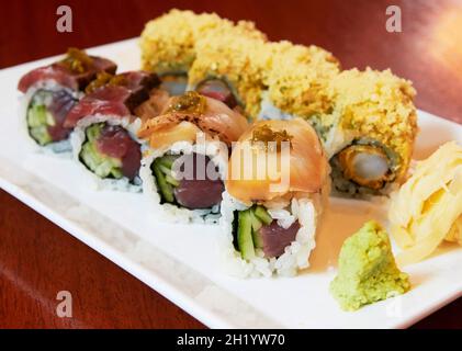 Verschiedene Arten von Sushi mit Wasabi und Ingwer auf einer Servierplatte Stockfoto