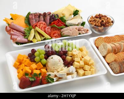 Verschiedene herzhafte und süße Snacks auf Platten Stockfoto