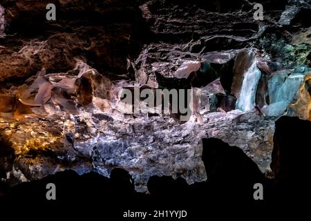 Dunkle, farbenfrohe Wandtexte in einer Lavaröhre der Insel Canaria. Stockfoto