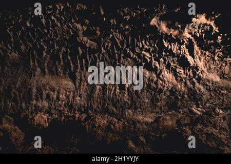 Dunkle, farbenfrohe Wandtexte in einer Lavaröhre der Insel Canaria. Stockfoto