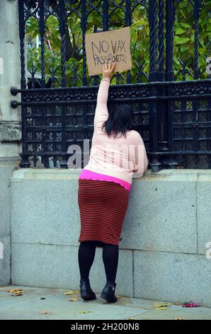 London, Großbritannien. Oktober 2021. Die eineiige Anti-vax-Passprotestierende greift nach oben, um den Politikern im Parlament ihr Zeichen zu zeigen, damit sie es lesen können. Kredit: JOHNNY ARMSTEAD/Alamy Live Nachrichten Stockfoto