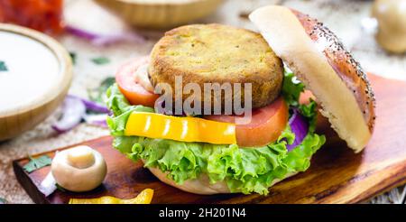 Vegetarischer Burger, ist ein fleischloses Sandwich aus Mais, Kartoffeln, texturiertem Sojaprotein, Hülsenfrüchten, Tofu, Pilze, Müsli Stockfoto