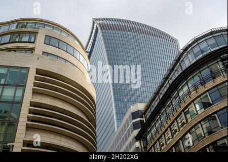 Blick auf das Walkie Talkie-Gebäude in der Fenchurch Street zwischen und hinter anderen Gebäuden von der Gracechurch Street, City of London, England. Stockfoto