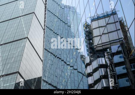 Lloyd's of London Gebäude spiegelt sich in der Glasfassade des Scalpel Gebäudes mit einem Teil der Cheesegrater auf der linken Seite, City of London, England. Stockfoto