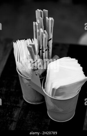 Essstäbchen und Servietten in Metallbehältern auf einem Tisch im Restaurant Stockfoto