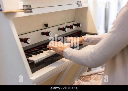 Eine Frau spielt den Argan. Hände und Tasten. Stockfoto