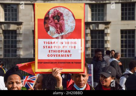 London, Großbritannien. Oktober 2021. Ein Protestler hält ein Plakat mit der Aufschrift „Tigray wird von der äthiopischen Regierung verhungert“ während der Demonstration vor der Downing Street. Demonstranten versammelten sich aus Protest gegen einen sogenannten "Völkermord-Krieg" von Äthiopien und Eritrea in der Region Tigray und riefen das Vereinigte Königreich und die internationale Gemeinschaft dazu auf, dem Volk von Tigray zu helfen. Kredit: SOPA Images Limited/Alamy Live Nachrichten Stockfoto