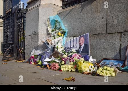 London, Großbritannien. Oktober 2021. Blumen und Ehrungen an den konservativen Parlamentsabgeordneten Sir David Amess vor dem Parlamentsgebäude.Sir David Amess wurde am 15. Oktober 2021 in Leigh-on-Sea ermordet und der Verdächtige, ein britischer Mann somalischer Herkunft, wurde verhaftet und nach dem Terrorismusgesetz inhaftiert. Kredit: SOPA Images Limited/Alamy Live Nachrichten Stockfoto