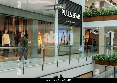 Quito, Pichincha, Ecuador, 11. September 2021. Eine Person läuft mit einer Maske vor einem Bershka- und Pull & Bear-Laden in einem Einkaufszentrum Stockfoto