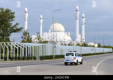 SCHALI, RUSSLAND - 29. SEPTEMBER 2021: Polizeiauto UAZ-Patriot vor dem Hintergrund der Moschee 'Stolz der Muslime' am Septembermorgen Stockfoto