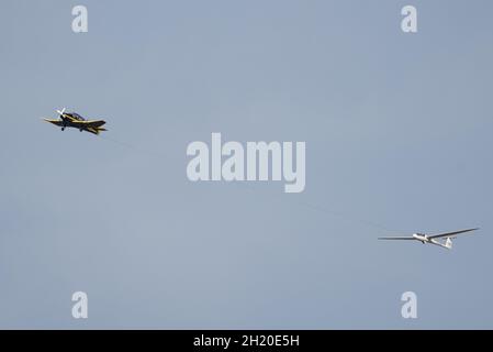 Ein Robin DR400 Schlepper (G-BJUD) schlepp einen Schempp-Hirth Discus Glider (G-CFXM) aus dem Lasham Gliding Center in Hampshire, Großbritannien Stockfoto