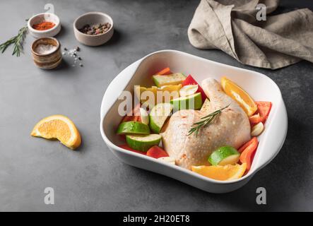 Rohes Hühnerfleisch mit Gemüse auf der Küchentheke Stockfoto