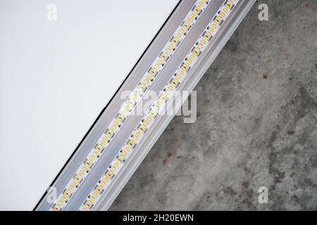 Streifen-LED-Licht mit Aluminiumprofil. Stretch-Decke mit LED-Beleuchtung im Haus oder in der Wohnung, innen, aus nächster Nähe. Renovierungskonzept für das Haus. Energy savi Stockfoto